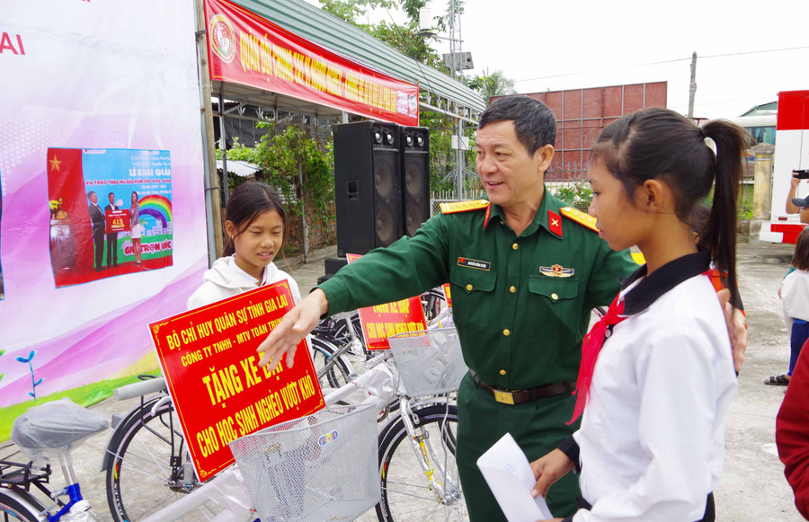 Đại tá Nguyễn Hồng Xuân-Phó chủ nhiệm Chinhtrị Bộ CHQS tỉnh tặng xe đạp cho học sinh nghèo vượt khó học giỏi. Ảnh: Anh Huy