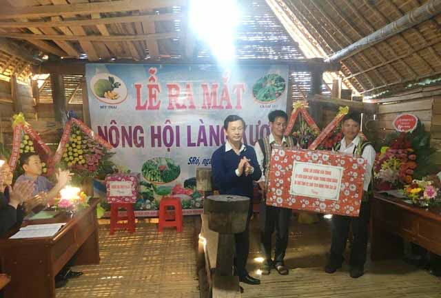 Bí thư Tỉnh ủy Dương Văn Trang (bên trái) tặng quà cho Nông hội làng Kươk. Ảnh: An Phát.