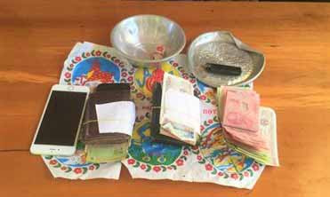 Tang vật tiền và dụng cụ lắc bầu cua thu giữ. Ảnh: Cúc Phương