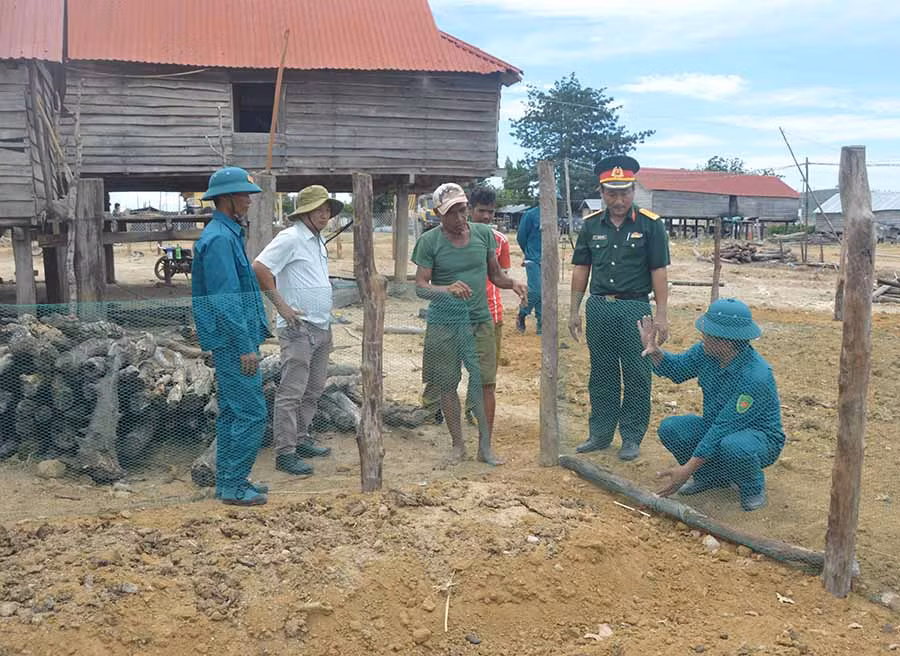 Lực lượng vũ trang huyện Phú Thiện hướng dẫn người dân làm hàng rào, vườn rau. Ảnh: Anh Huy
