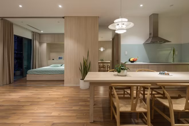 Bức tường đối diện bàn ăn được lắp gương, khiến căn hộ như có thêm một gian phòng nữa.