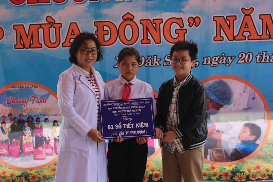 Gia đình bác sĩ Nguyễn Tri Thức (Giám đốc Bệnh viện Chợ Rẫy TP.Hồ Chí Minh) tặng sổ tiết kiệm cho em Đinh Thị Thang. Ảnh: Phan Lài