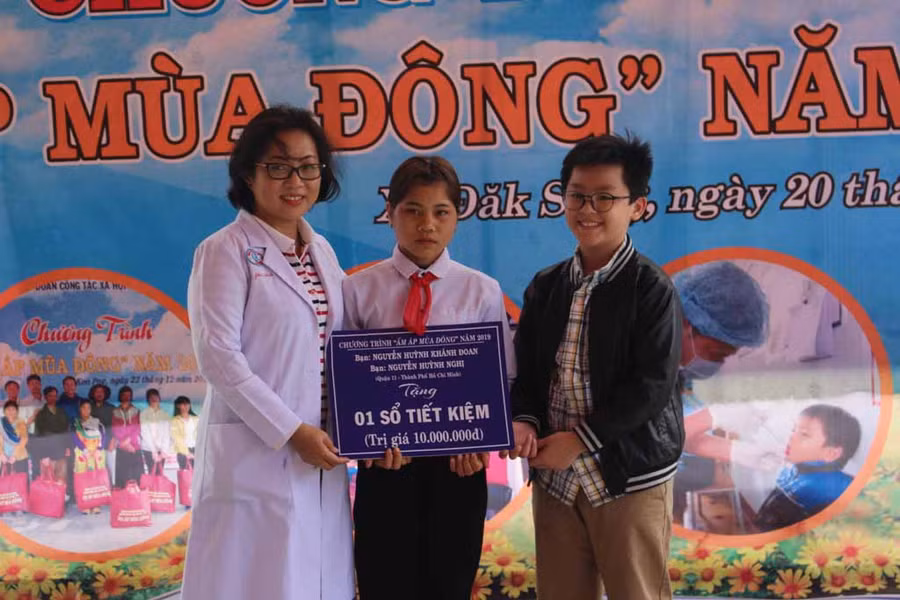 Gia đình bác sĩ Nguyễn Tri Thức (Giám đốc Bệnh viện Chợ Rẫy TP.Hồ Chí Minh) tặng sổ tiết kiệm cho em Đinh Thị Thang. Ảnh: Phan Lài