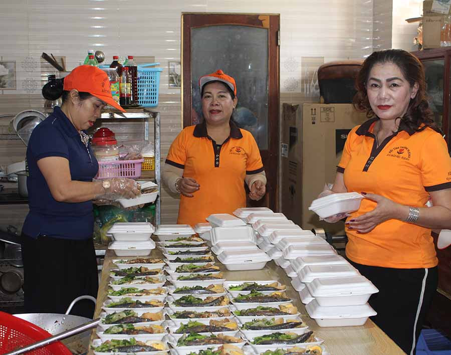  Thành viên Hội tình thương Pleiku chuẩn bị cơm để trao cho bệnh nhân nghèo. Ảnh: T.B