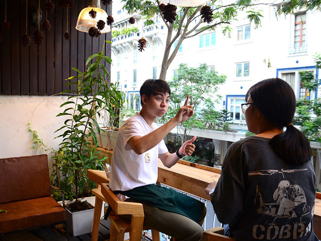 Bạn trẻ đến quán rất thích thú khi được học ngôn ngữ ký hiệu - Ảnh: Nữ Vương