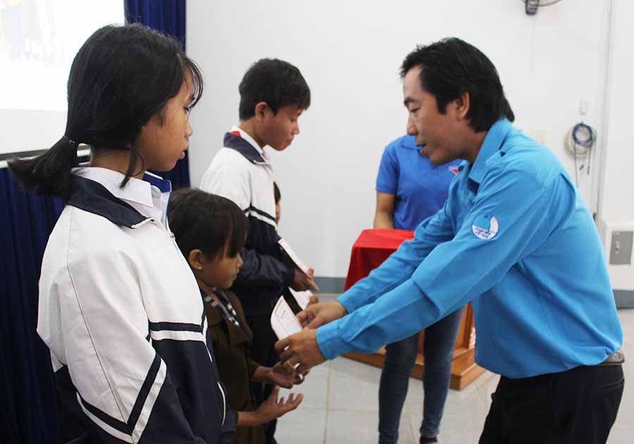 1Ông Trần Thanh Bình-Phó Giám đốc Trung tâm Công tác xã hội thanh thiếu niên trao sổ tiết kiệm cho học sinh khó khăn-Ảnh PL