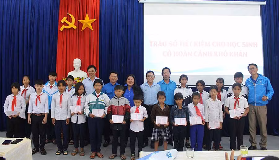  Ban tổ chức chụp hình cùng các học sinh dân tộc thiểu số được nhận sổ tiết kiệm. Ảnh: T.B