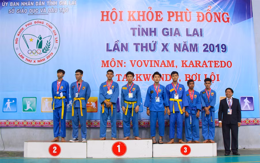 Trao thưởng cho các vận động viên đạt giải ở nội dung Song luyện nam khối THPT. Ảnh: Mộc Trà