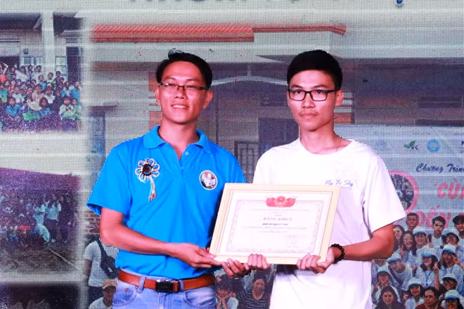 Phúc (bên phải) nhận bằng khen vì có nhiều dự án cho cộng đồng - Ảnh: Đức Nhật