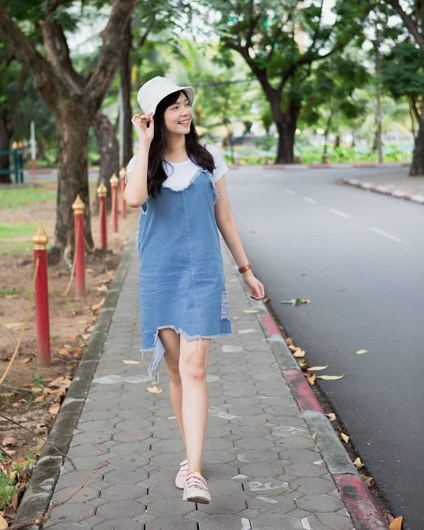 Người đẹp Thái Lan chọn trang phục “Sương sương” với đầm hai dây jeans mix cùng áo thun cùng mũ xô khi ra phố