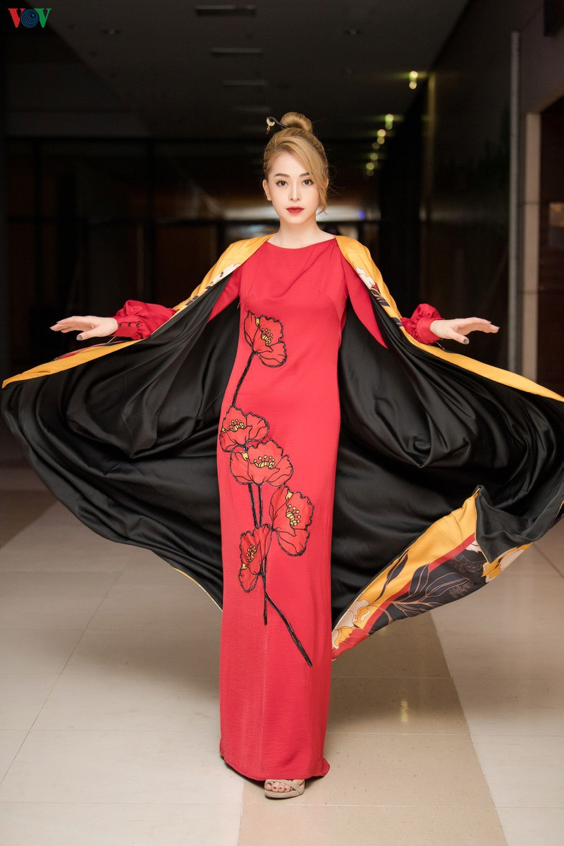 Thiết kế áo dài kết hợp với áo choàng họa tiết hoa sen đầy màu sắc dường như làm cho nàng Á hậu nổi bật hơn.