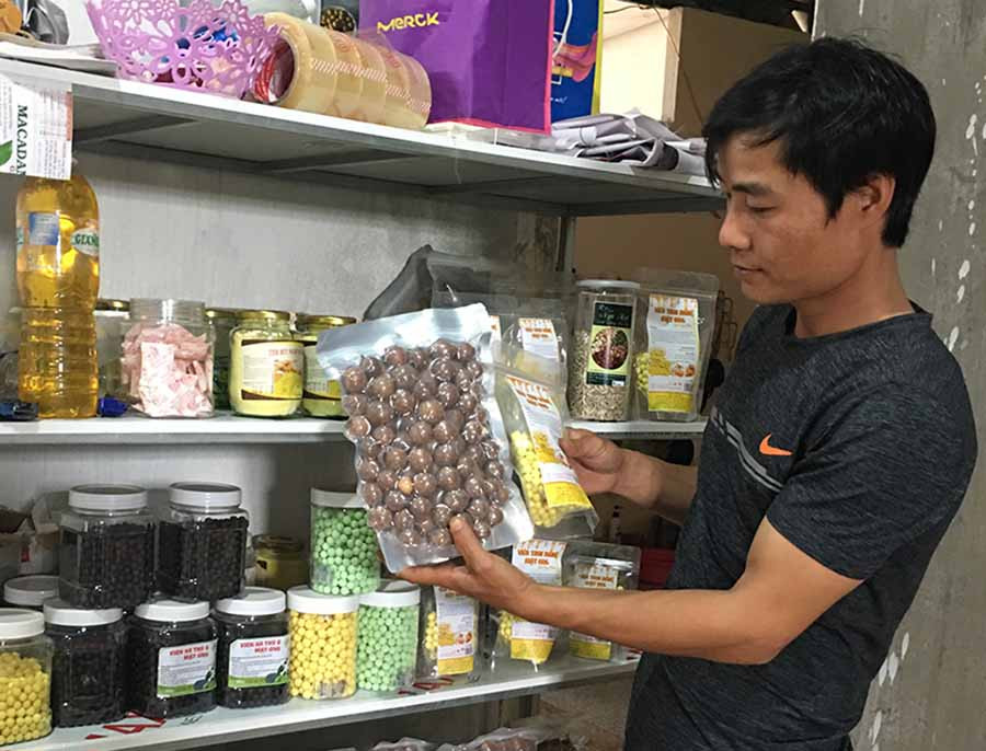  Anh Nguyễn Đình Thanh và các sản phẩm do Công ty Sami Gia Lai chế biến. Ảnh: V.T