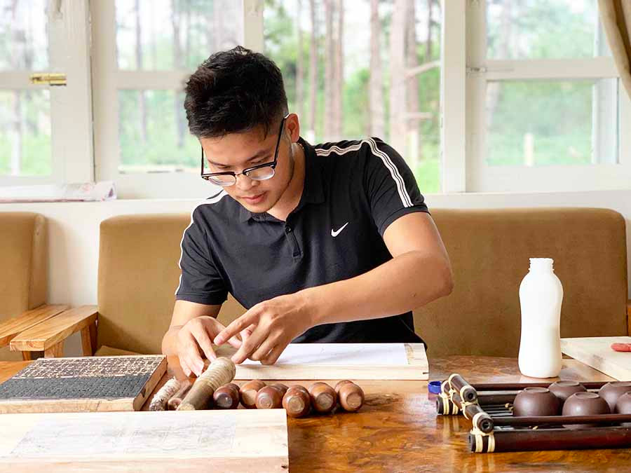  Dán văn bản lên bản mộc cũng đòi hỏi sự kỳ công, tỉ mỉ. Ảnh: P.L