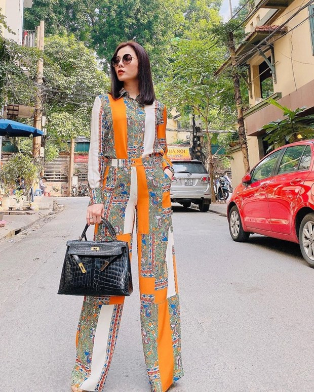 Lệ Quyên ''chơi trội'' với sơmi và quần ống loe họa tiết, phối theo phong cách matchy-matchy. Với điểm nhấn là chiếc túi Hermès đắt giá, ''nữ hoàng Bolero'' càng ra dáng nữ doanh nhân thành đạt.