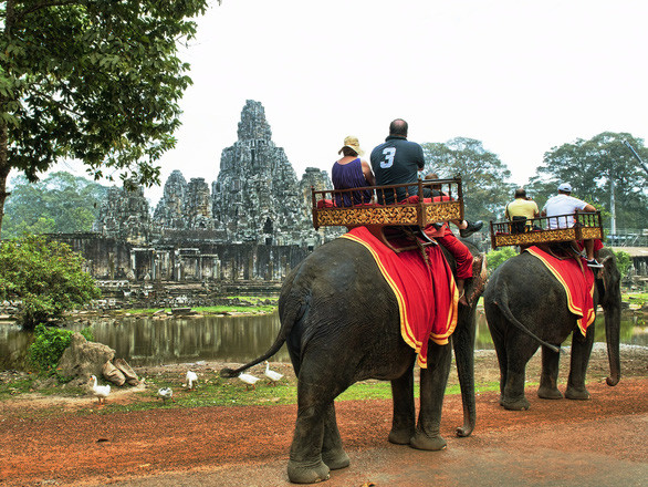 Du khách cưỡi voi ở khu Angkor - Ảnh: CNN