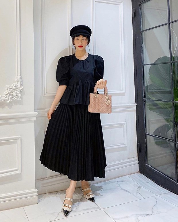 Chung lựa chọn chân váy midi với nhiều đàn chị, Hòa Minzy ưu tiên thiết kế tuyền đen cổ điển. Cô nàng phối chân váy với áo peplum tay phồng và giày, mũ ton-sur-ton. Chiếc túi Dior hồng phấn là phụ kiện ''thắp sáng'' tổng thể một cách hoàn hảo.