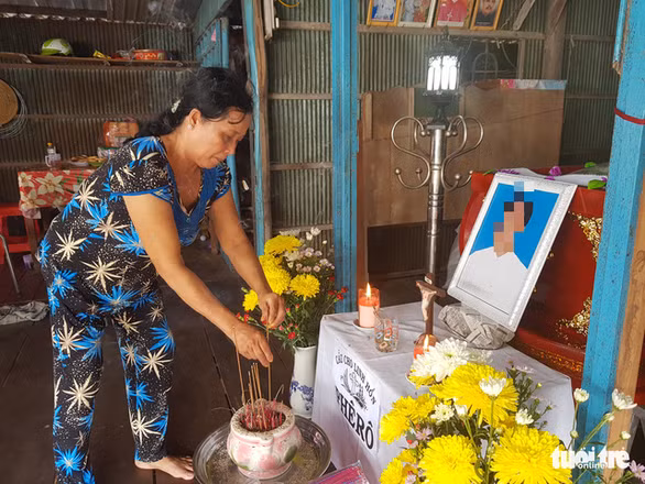 Bà Trần Thị Tuyết, mẹ ruột C., thắp hương cho con trai - Ảnh: BỬU ĐẤU