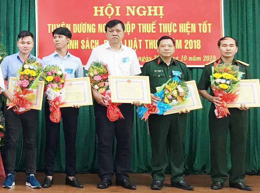  Giám đốc Công ty Bảo Việt Gia Lai (giữa) nhận giấy khen của Cục Thuế tỉnh dành cho đơn vị hoàn thành tốt nghĩa vụ thuế. Ảnh: H.D