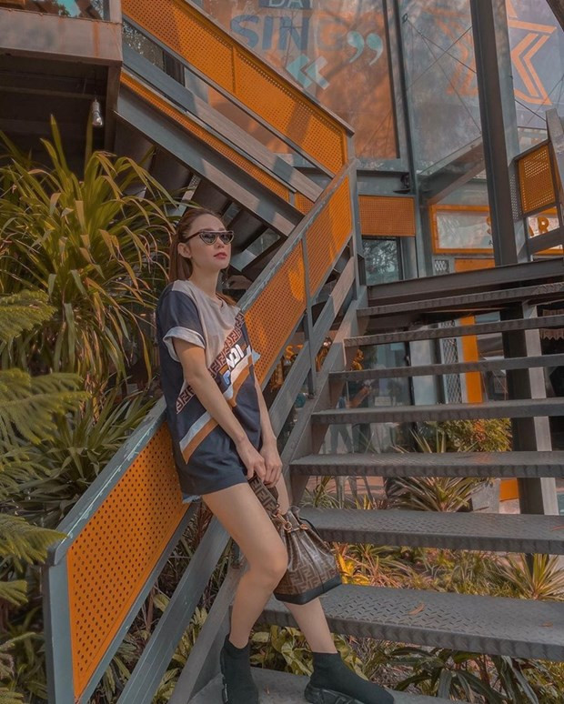  Minh Hằng thể hiện mình là tín đồ của Fendi khi biến áo phông dáng rộng của hãng thành đầm, mặc theo công thức giấu quần. Nữ ca sĩ còn mang túi bucket cũng của Fendi, vừa tạo sự đồng điệu vừa làm bật phong cách trẻ trung, khỏe khoắn.