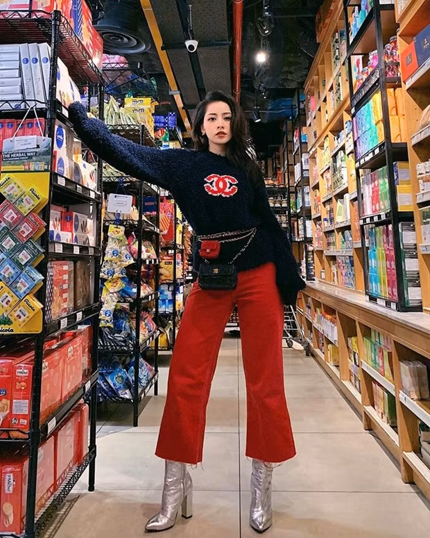 Chi Pu không chỉ bắt nhịp trào lưu mà còn trổ tài phối đồ ''điệu nghệ''. Cô nàng kết hợp áo len có logo Chanel với quần culottes đỏ. Layer thắt lưng kèm túi mini kích thước khác nhau, cộng thêm boots ánh kim giúp Chi Pu càng thêm thời thượng.