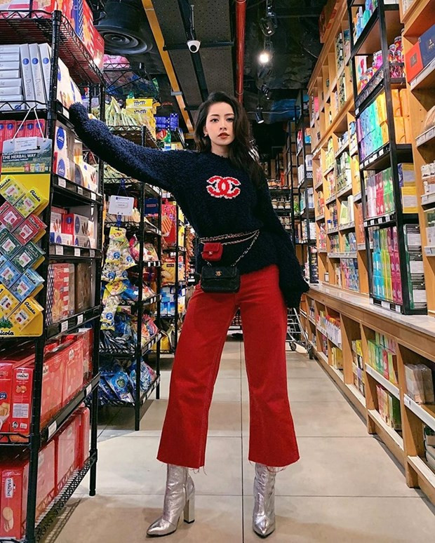 Chi Pu không chỉ bắt nhịp trào lưu mà còn trổ tài phối đồ ''điệu nghệ''. Cô nàng kết hợp áo len có logo Chanel với quần culottes đỏ. Layer thắt lưng kèm túi mini kích thước khác nhau, cộng thêm boots ánh kim giúp Chi Pu càng thêm thời thượng.