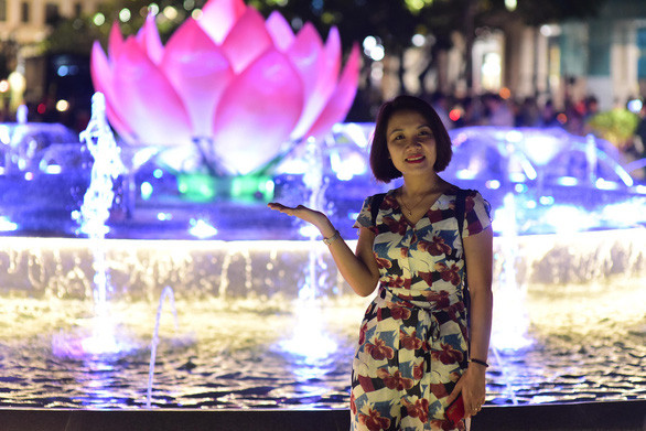 Du khách chụp ảnh kỷ niệm trong ngày khánh thành đài phun nước nghệ thuật - Ảnh: Q.ĐỊNH