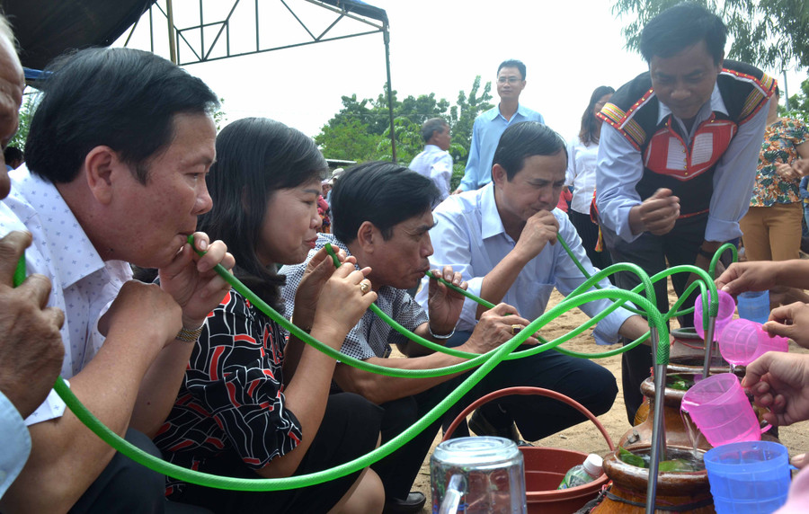 Lãnh đạo tỉnh uống rượu cần chung vui trong Ngày hội Đại đoàn kết toàn dân tộc buôn Bhă Nga. Ảnh: Lê Hoà