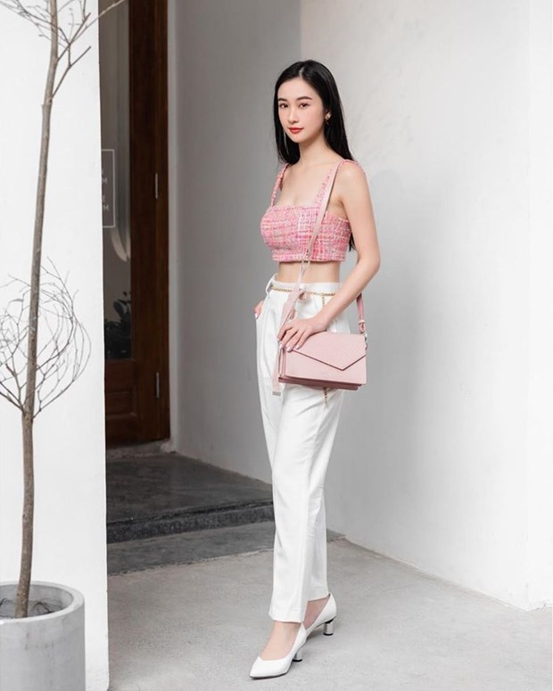 Jun Vũ khai thác lợi thế eo thon nhờ trưng dụng crop top. Tuy nhiên, thay vì chân váy ngắn hay quần shorts, cô nàng kết hợp chiếc áo quai dây với quần ống đứng. Phép cộng này không lạm dụng các khoảng hở mà để lộ chừng mực những ''điểm vàng'' quyến rũ.