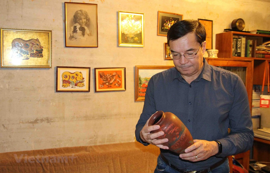 Anh Zhenya xem những kỷ vật gắn liền với đất nước Việt Nam. (Ảnh do nhân vật cung cấp/Vietnam+)