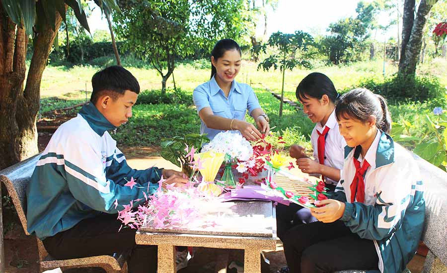  Cô giáo Trần Thị Kim Loan cùng các em học sinh làm đồ dùng trang trí lớp học từ vật liệu tái chế. Ảnh: T.B