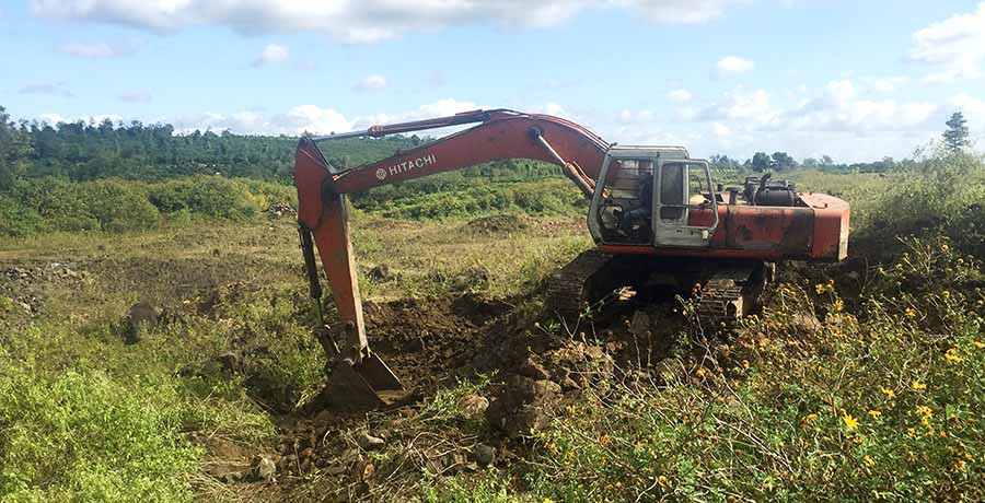 Máy xúc đang đào bới tìm kiếm đá tại cánh đồng làng Rin Rai. Ảnh: Văn Ngọc