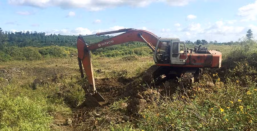 Máy xúc đang đào bới tìm kiếm đá tại cánh đồng làng Rin Rai. Ảnh: Văn Ngọc