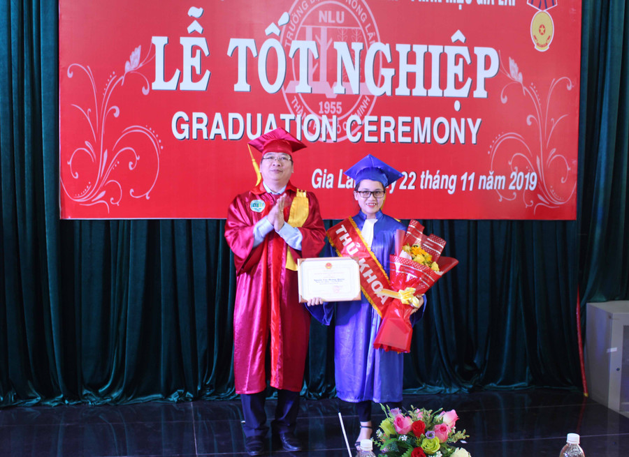 Tiến sĩ Trần Đình Lý tặng giấy khen cho sinh viên Nguyễn Cao Hoàng Quyên-tốt nghiệp thủ khoa ngành Lâm nghiệp. Ảnh: Phan Lài