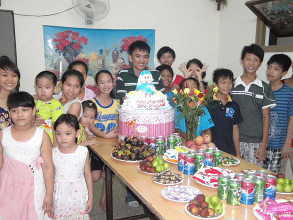 Trong bức ảnh chụp năm 2011 này, anh sinh viên tình nguyện Ben Hoàng Nguyễn đang mừng sinh nhật cùng các em nhỏ ở trại mồ côi Thủy Xuân và giải thích với các em một buổi sinh nhật được tổ chức như thế nào - Ảnh: NVCC
