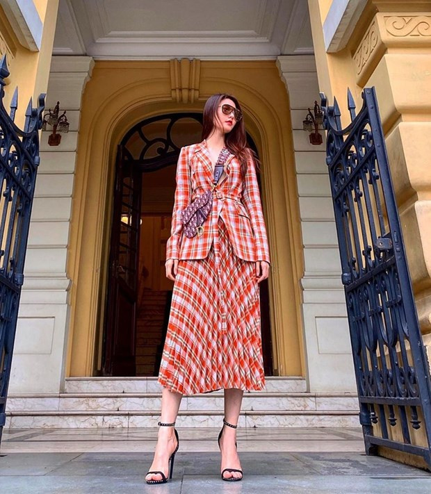  Cũng chọn phong cách matchy-matchy làm ''kim chỉ nam'', Diễm My 9X bắt cặp blazer và chân váy kẻ tartan đồng điệu. Chiếc túi Saddle của Dior là phụ kiện nhấn cho trang phục, khiến nhân vật chính tăng vẻ sang trọng, trẻ trung.