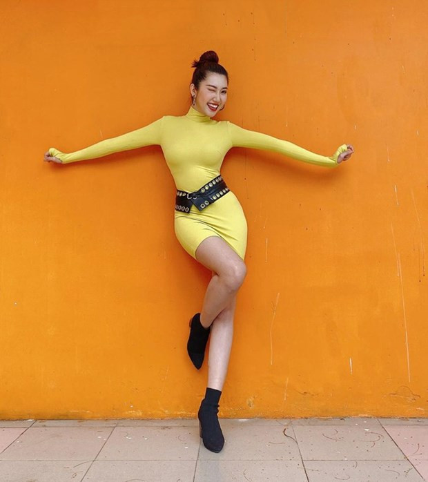 Đường cong ''chữ S'' của Thúy Ngân được dịp phô diễn triệt để nhờ chiếc đầm cổ lọ bó sát, phủ sắc vàng chói chang.