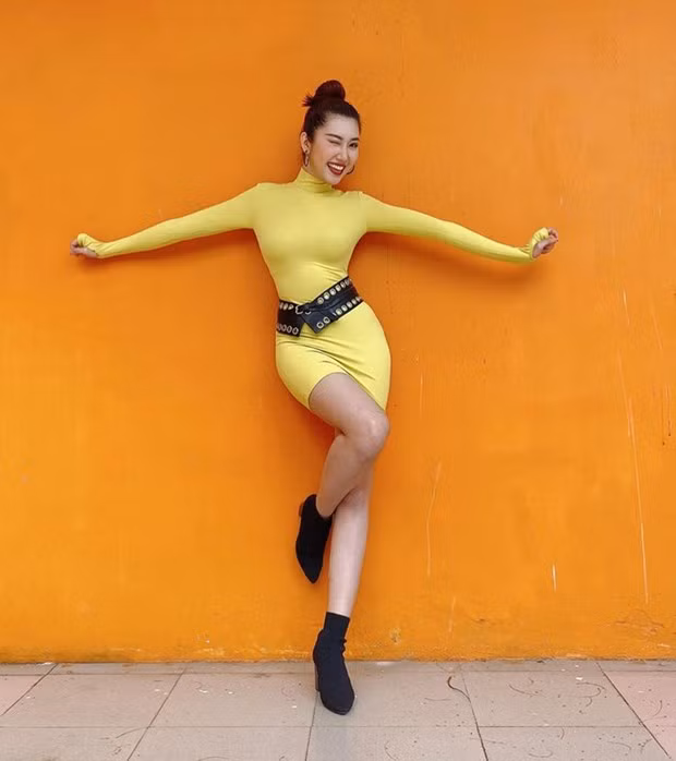 Đường cong ''chữ S'' của Thúy Ngân được dịp phô diễn triệt để nhờ chiếc đầm cổ lọ bó sát, phủ sắc vàng chói chang.