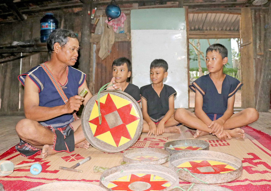 Nghệ nhân Đinh Jam (làng Leng, xã Tơ Tung, huyện Kbang) hướng dẫn kỹ thuật đánh cồng chiêng cho thiếu nhi. Ảnh: Ngọc Minh