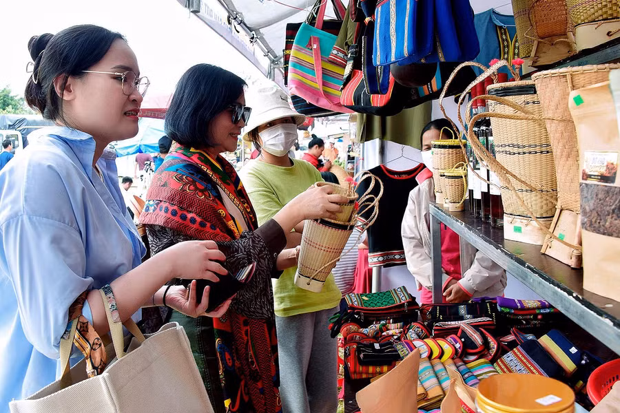 Du khách hào hứng với những món quà lưu niệm mang đậm bản sắc văn hoá. Ảnh Đức Thuỵ 