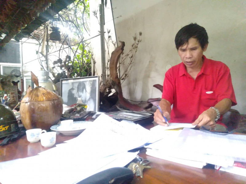 Ông Đào Hà đang kiểm tra tài liệu ghi chép về các kỷ vật.