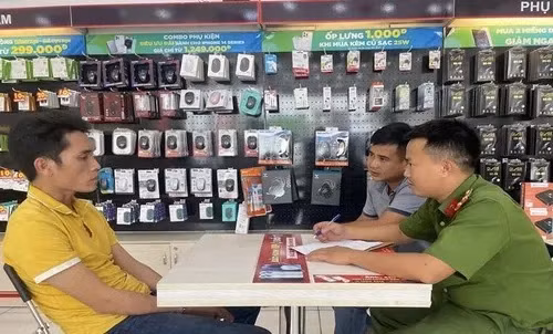 Lê Phan Anh Thuận (trái) làm việc với công an