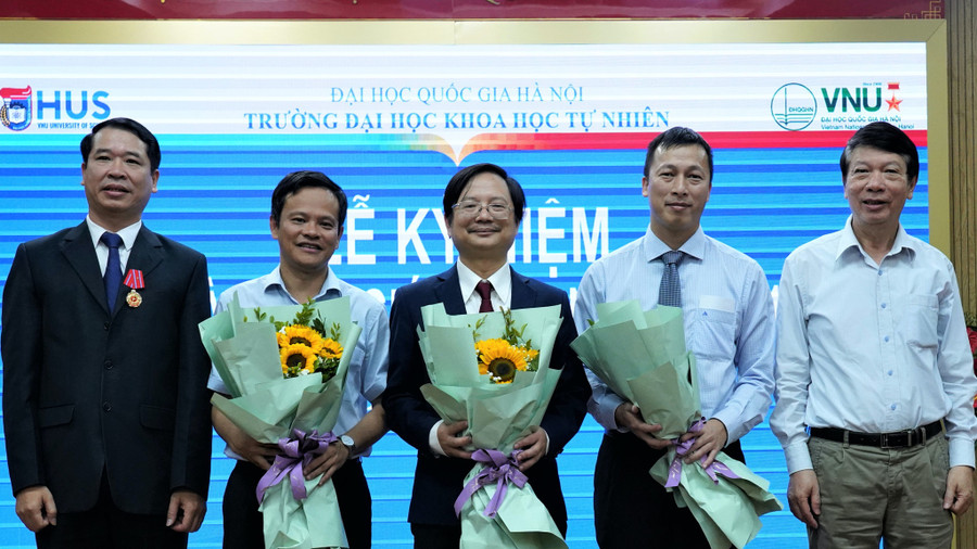 Các nhà giáo của Trường ĐH Khoa học tự nhiên, ĐH Quốc gia Hà Nội (3 người ở giữa) nhận hoa chúc mừng vì mới được công nhận đạt tiêu chuẩn giáo sư. Ảnh: HUS