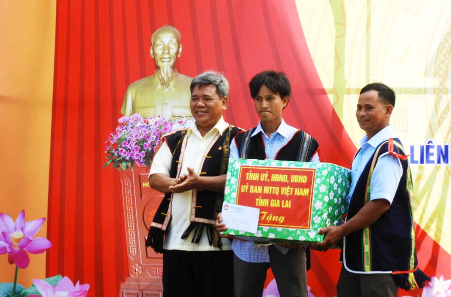 Chủ tịch Ủy ban MTTQ Việt Nam tỉnh Hồ Văn Điềm thay mặt lãnh đạo tỉnh tặng quà của tỉnh cho tập thể làng Đak Yă và Đak Trôk. Ảnh: Thanh Nhật