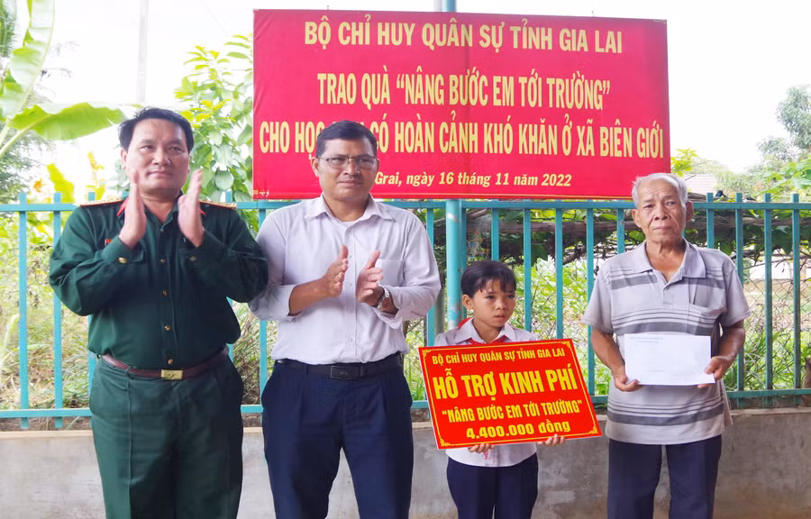 Đại tá Phạm Mạnh Hùng thăm, tặng quà cho em Rơ Lan Quýt (làng Bi, xã Ia O, huyện Ia Grai). Ảnh: Huy Bắc