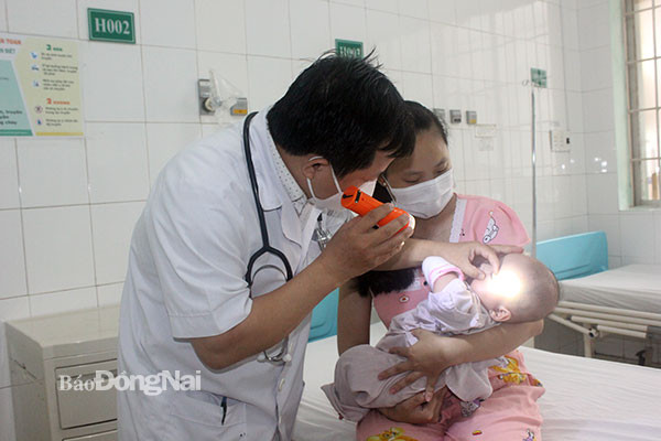 Bác sĩ kiểm tra sức khỏe cho bệnh nhi sáng 22-11. Ảnh: Báo Đồng Nai Bác sĩ kiểm tra sức khỏe cho bệnh nhi sáng 22-11. Ảnh: Báo Đồng Nai