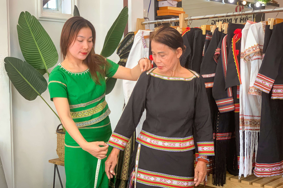  Chị Y Dương đo, may trang phục cho khách. Ảnh:N.S