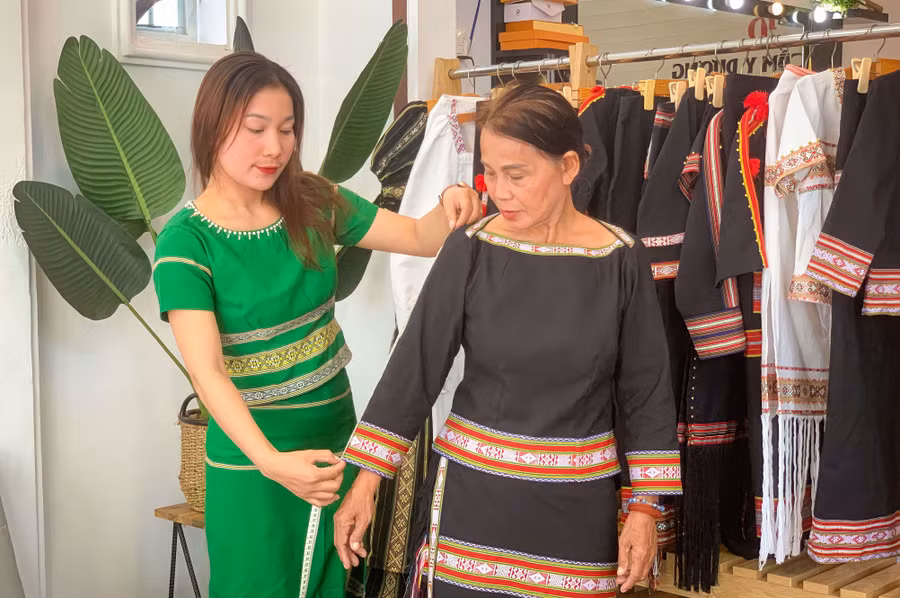 Chị Y Dương đo, may trang phục cho khách. Ảnh:N.S