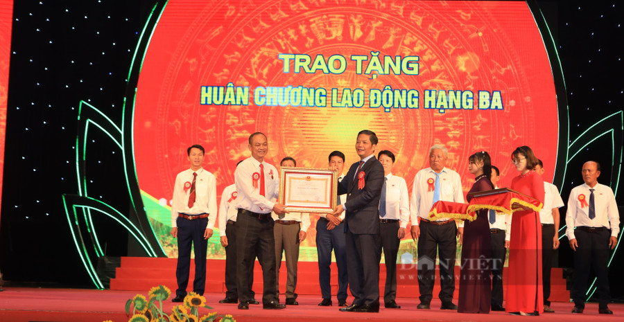 Thay mặt lãnh đạo Đảng, Nhà nước, ông Trần Tuấn Anh - Uỷ viên Bộ Chính trị, Trưởng ban Kinh tế Trung ương trao tặng Huân chương Lao động hạng Ba cho tỷ phú nông dân Tống Văn Hướng (SN 1970) ở xã Minh Hòa, huyện Dầu Tiếng, tỉnh Bình Dương. Ảnh: Đức Quảng.