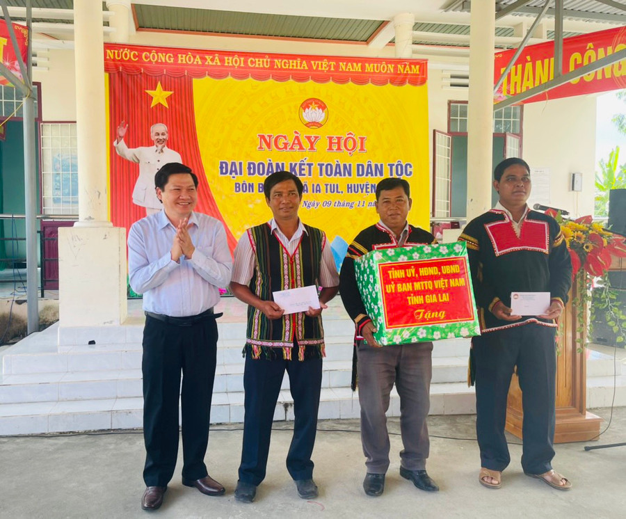 Phó Chủ tịch Thường trực HĐND tỉnh Trương Văn Đạt (bìa trái) tặng quà cho cán bộ và bà con buôn Biah B. Ảnh: Vũ Chi
