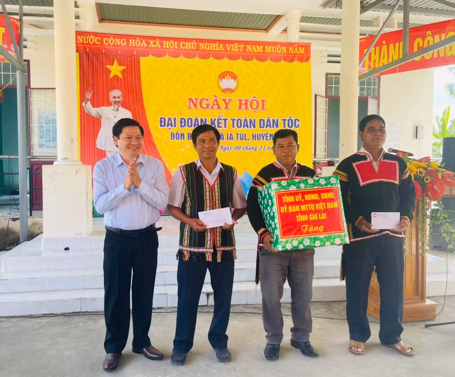 Phó Chủ tịch Thường trực HĐND tỉnh Trương Văn Đạt (bìa trái) tặng quà cho cán bộ và bà con buôn Biah B. Ảnh: Vũ Chi